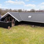 Moderne Hütte mit Terrasse, Grill und Garten. Dach mit Dachfenster. Umgeben von Wald.
