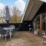 Terrasse mit Tisch, Stühlen, Sonnenschirm und Grill.