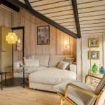 Wohnzimmer mit Sofa, Sessel und Holzwandverkleidung