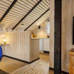 Wohnbereich mit Holzwand, Küchenzeile und Fernseher
