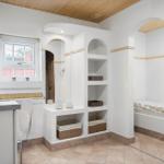 Badezimmer mit Dusche, Regalen und Fenster. Holzdecke und Fliesenboden.