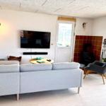 Wohnzimmer mit Sofa, Fernseher und Kamin