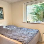 Ein Schlafzimmer mit Bett, Fenster und Wandbild.