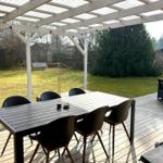Terrasse mit Tisch und Stühlen unter Dach