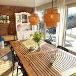 Esszimmer mit Holztisch, Hängelampen und Blick auf Balkon
