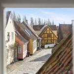 View through window onto street with traditional houses and cobblestone