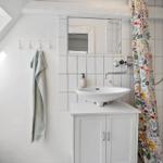 Bathroom with sink, mirror, and shower curtain.