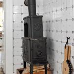 Black stove with wood box and tiled wall