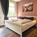 Schlafzimmer 1 von 5 mit Babybett sowie Kleiderschrank, Stummer Diener und Hocker.