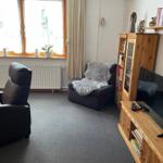 Wohnzimmer mit Schränken und Schlafsesselp