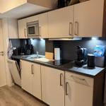 Kitchen with white cabinets, dark countertop, and built-in microwave.