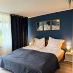 Bedroom with bed, blue wall, and window with curtains.