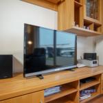TV auf Holzboard mit Lautsprecher und Aufbewahrungskompartimenten