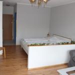 Schlafzimmer mit Bett, Sofa und Holzboden