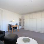 Wohnzimmer mit Esstisch, Sofa und integrierten Schränken.