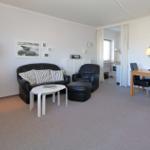 Wohn- und Essbereich mit Sofa, Sessel und Esstisch.