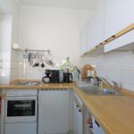 Küche mit Arbeitsplatte, Spüle, Herd und Küchenutensilien.