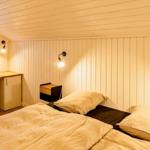 Schlafzimmer mit Bett, Nachttisch, Schreibtisch und Fenster.