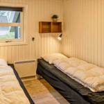 Zwei Betten mit Decken, Wandhalterung und Fenster mit Blick nach draußen.
