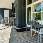 Terrasse mit Tischen und Stühlen, Glasfront und Holzdielen