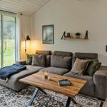 Wohnzimmer mit Sofa, Holztisch und Blick auf Garten