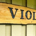 Holzschild mit der Aufschrift VIOLEN an einer Hauswand.