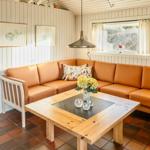 Ein Wohnzimmer mit orangefarbenem Sofa, Holztisch und Fenster.