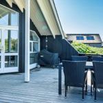 Terrasse mit Tisch und Stühlen, Blick auf Grünfläche und Haus