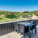 Terrasse mit Tisch und Stühlen. Blick auf Grünflächen und Wohnhäuser.