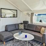 Wohnzimmer mit grauem Sofa, runden Tisch und Blick aufs Gras.