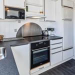 Küche mit Arbeitsplatte, Spüle, Herd und Kühlschrank