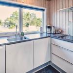 Küche mit Fenster, Spüle, Kochfeld und Waschmaschine