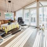 Wohnzimmer mit Sitzgelegenheiten, Esstisch und Kaminofen. Blick auf Balkon.