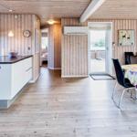 Küche mit Essbereich, Holzwand und Tisch mit Stühlen