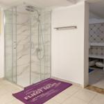 Dusche mit Glaswand, Badematte und Duschbrause