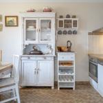 Küche mit weißem Sideboard, Esstisch und moderner Küchenzeile.