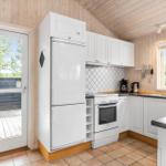 Kitchen with white cabinets, refrigerator, and view of the terrace.