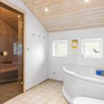 Bath with whirlpool, sauna, and windows with bird decoration.