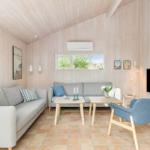 Living room with two sofas, table, chair, and TV mounted on the wall.