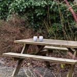Holzpicknicktisch mit zwei Tassen im Garten