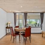 Esszimmer mit Holztisch, roten Stühlen und Fenster zur Terrasse.