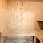 Sauna mit Holzwandverkleidung und mehreren Sitzbänken.