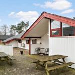 Wohnhaus mit Terrasse, Tischen und Stühlen im Freien.