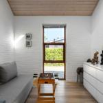 Wohnzimmer mit Sofa, Tischfußball und Fenster zum Garten