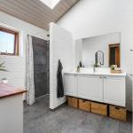Badezimmer mit Dusche, Waschbecken und Fenster
