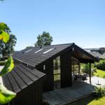 Moderne Holzhütte mit Terrasse, Garten und Meerblick.