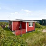 Rotes Strandhaus mit Terrasse und Blick aufs Wasser