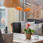 Ein Wohnzimmer mit grauem Sofa, Tisch und Fensterblick.