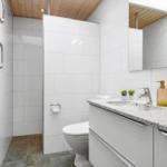 Badezimmer mit Dusche, Toilette und Waschbecken mit Spiegel.