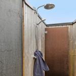 Außen-Dusche mit Duschbrause und Handtuch an Wand